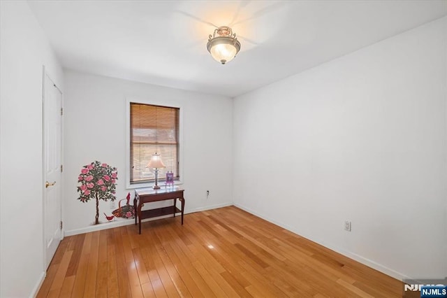 empty room with baseboards and wood finished floors