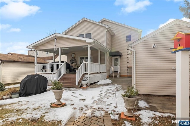 snow covered property with a porch