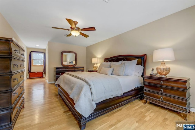 bedroom with light wood finished floors, baseboards, and a ceiling fan