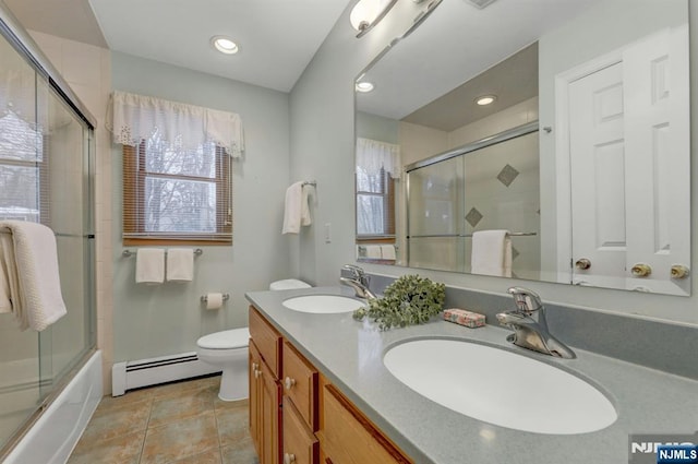 full bathroom with shower / bath combination with glass door, a baseboard radiator, a sink, and toilet