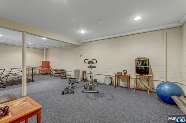 exercise room featuring concrete block wall and recessed lighting