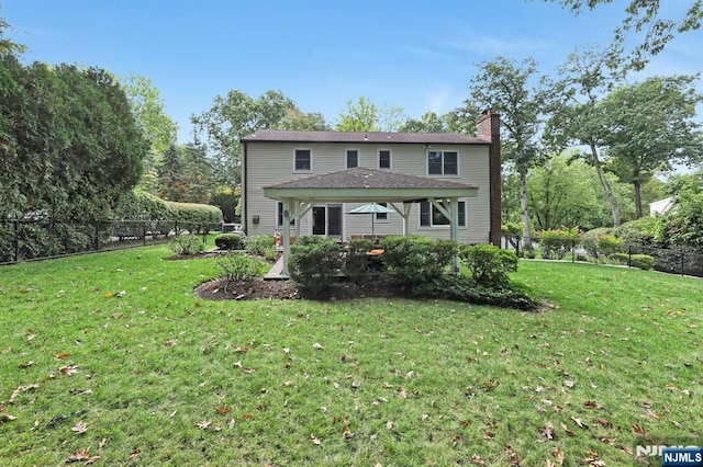 view of front of property with a fenced backyard, a chimney, and a front yard