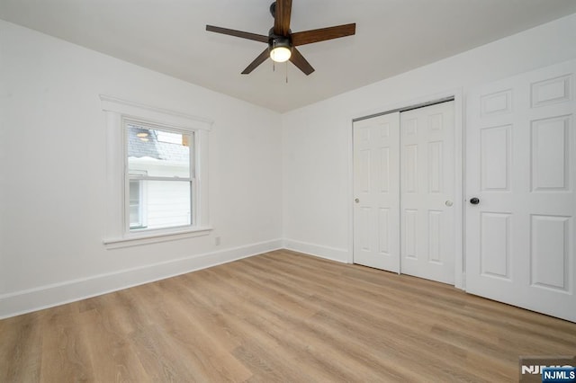 unfurnished bedroom with light hardwood / wood-style floors, a closet, and ceiling fan