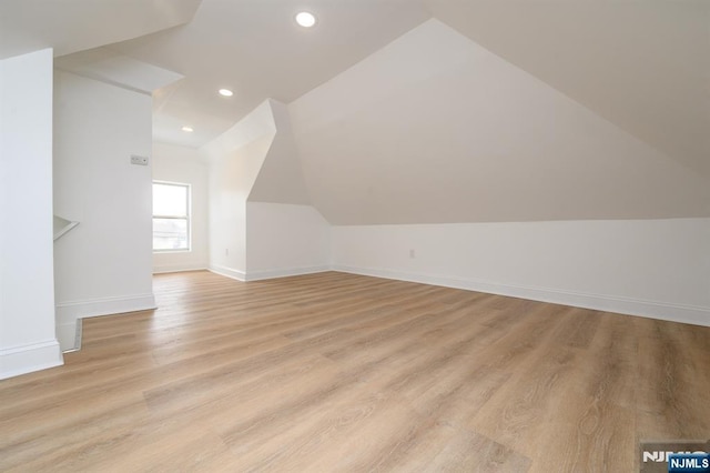 bonus room featuring lofted ceiling and light wood-type flooring