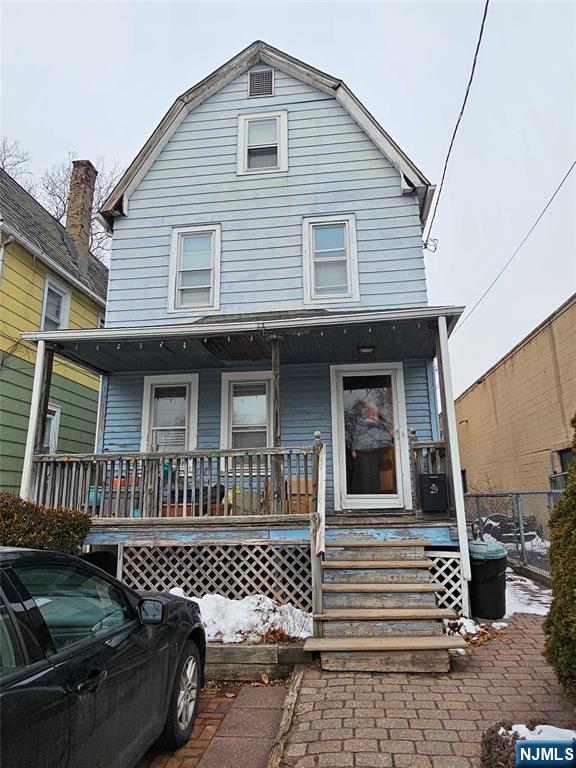 view of front facade with a gambrel roof and a porch