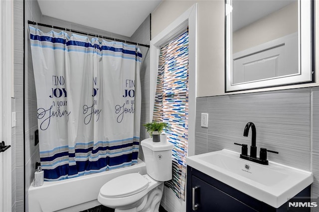 full bathroom with vanity, toilet, tile walls, and shower / bath combo