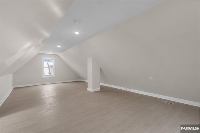 bonus room featuring vaulted ceiling and light hardwood / wood-style flooring