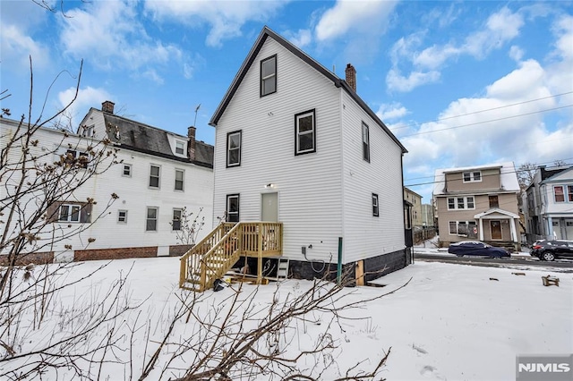 view of snow covered back of property