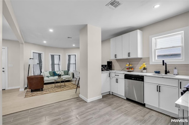 kitchen featuring white cabinetry, sink, decorative backsplash, and stainless steel dishwasher