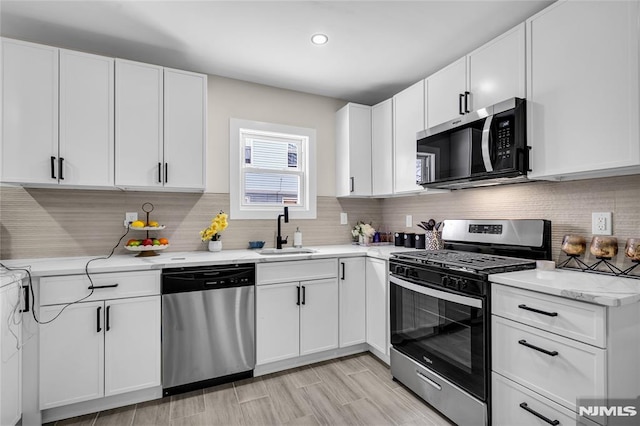 kitchen featuring stainless steel appliances, white cabinetry, and sink