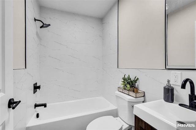 full bathroom featuring vanity, tiled shower / bath combo, tile walls, and toilet