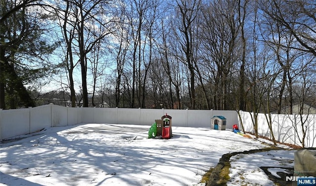 yard covered in snow with a fenced backyard