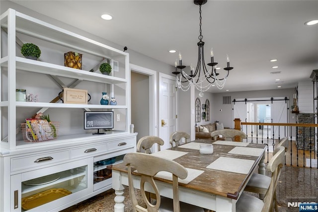 dining area with recessed lighting, a notable chandelier, and a barn door