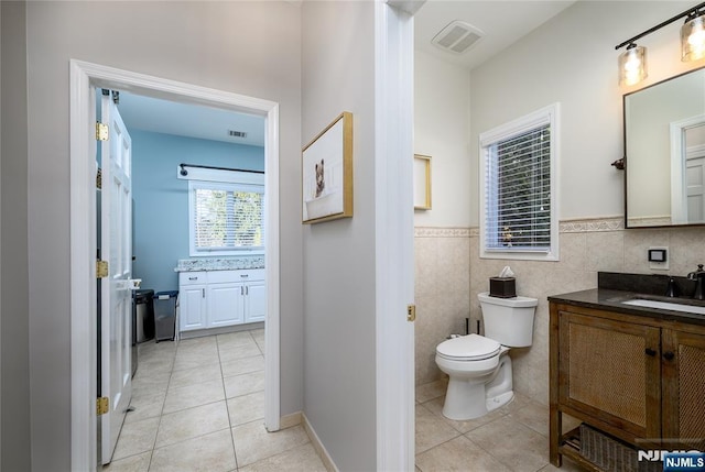 bathroom with toilet, vanity, visible vents, and tile patterned floors