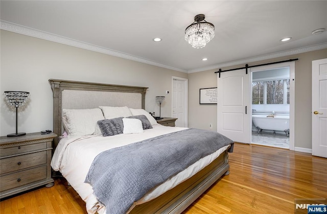 bedroom with crown molding, recessed lighting, a barn door, a chandelier, and light wood-type flooring