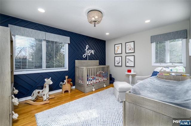 bedroom featuring baseboards, wood finished floors, and recessed lighting