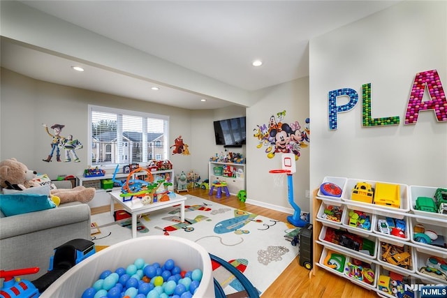 recreation room with recessed lighting, baseboards, and wood finished floors