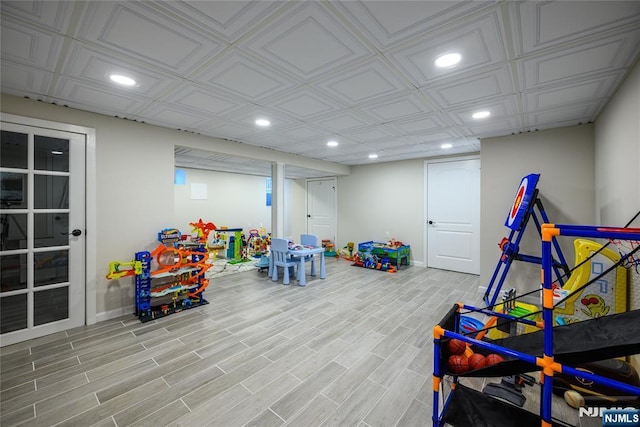 recreation room with baseboards, wood finished floors, and recessed lighting