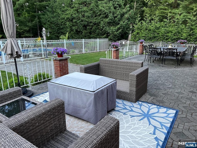 view of patio / terrace featuring a swimming pool, outdoor dining area, fence, and an outdoor living space