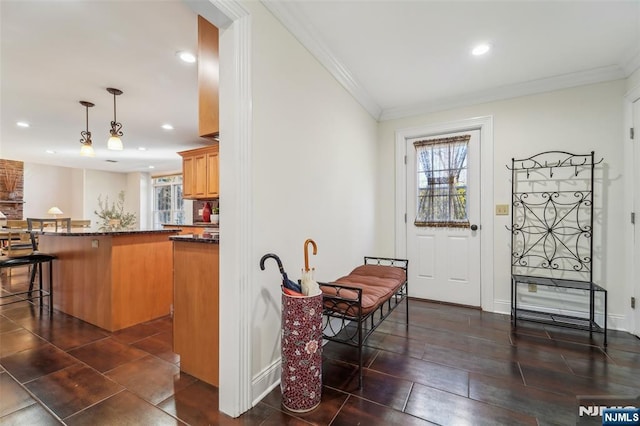 interior space with hanging light fixtures, baseboards, ornamental molding, and recessed lighting