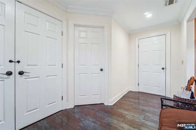 foyer featuring baseboards, visible vents, and crown molding