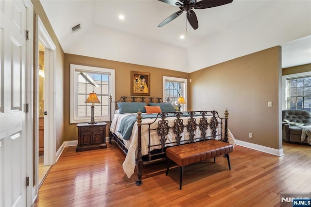 bedroom with lofted ceiling, light wood-style flooring, visible vents, and baseboards