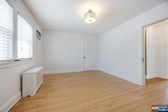 unfurnished room with radiator heating unit and light hardwood / wood-style flooring