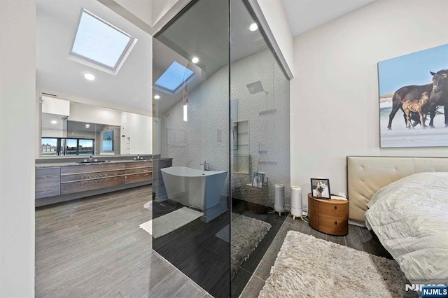 bathroom featuring high vaulted ceiling, a skylight, independent shower and bath, hardwood / wood-style flooring, and vanity