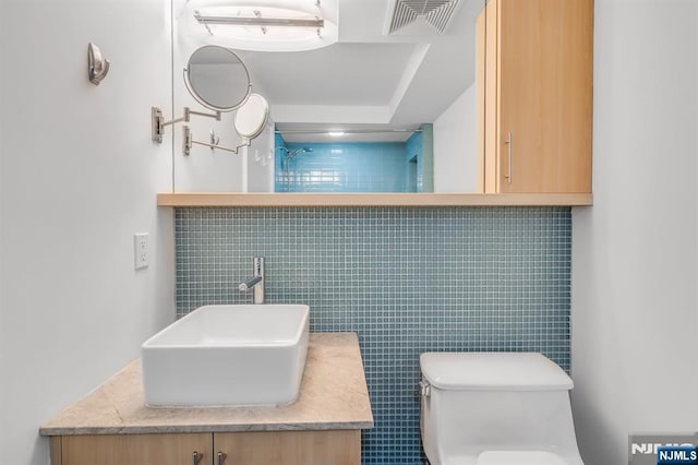 bathroom featuring vanity, tile walls, and toilet