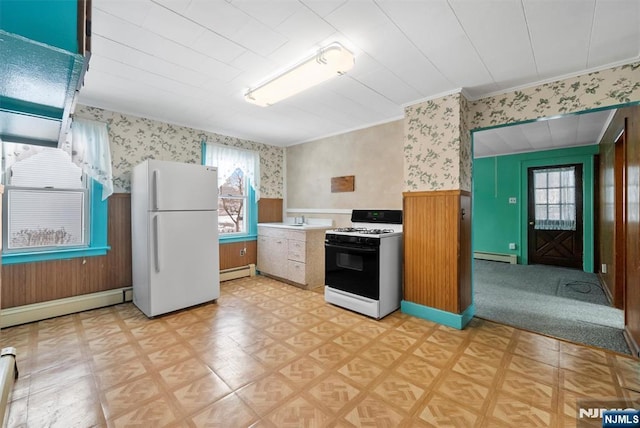 kitchen with gas range, plenty of natural light, baseboard heating, and white refrigerator