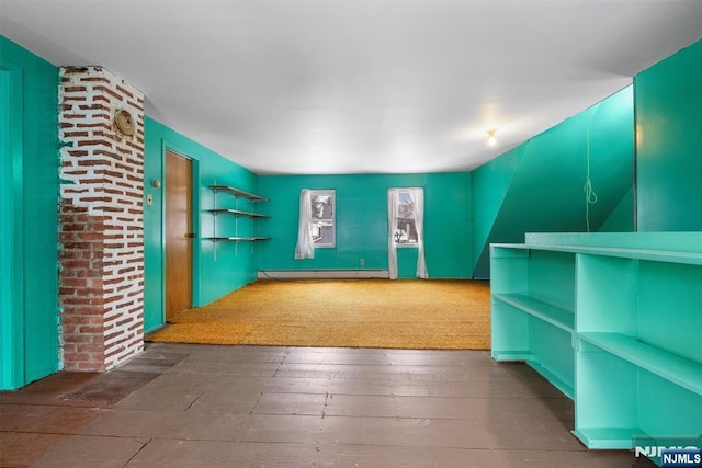 additional living space featuring a baseboard radiator and dark hardwood / wood-style floors