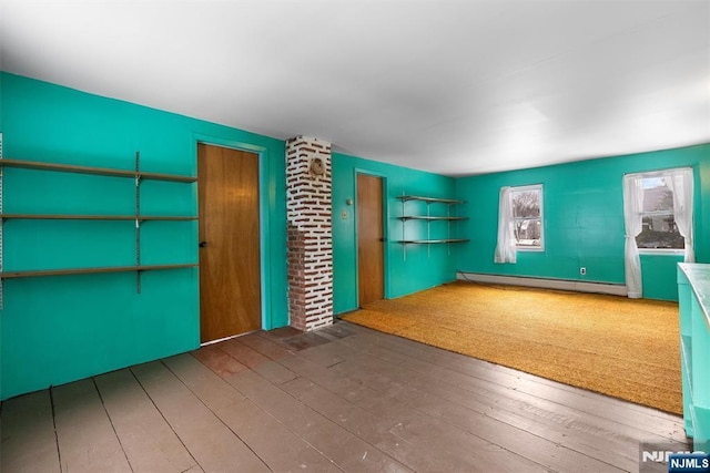 interior space featuring wood-type flooring and a baseboard heating unit