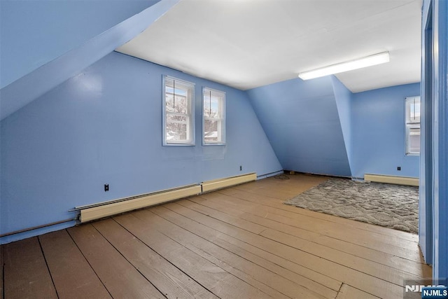 bonus room featuring vaulted ceiling, baseboard heating, and light hardwood / wood-style floors