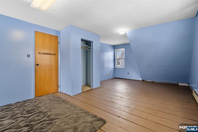 interior space featuring a baseboard radiator, light hardwood / wood-style floors, and a closet