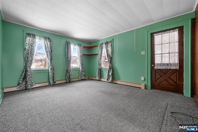 spare room with a baseboard radiator, carpet floors, and crown molding