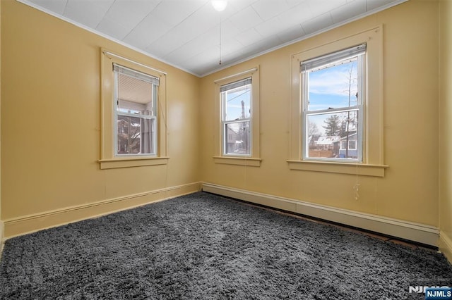 carpeted spare room with crown molding and a baseboard radiator