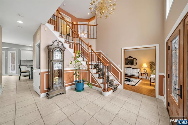 tiled entrance foyer featuring an inviting chandelier and a high ceiling