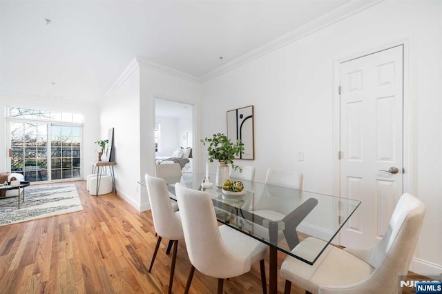 dining area featuring ornamental molding and light wood-type flooring