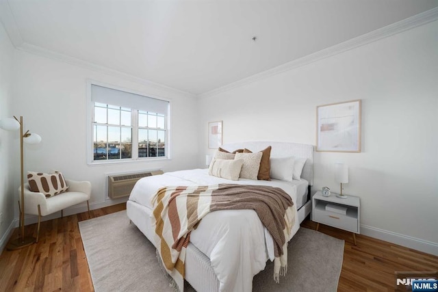 bedroom featuring ornamental molding, an AC wall unit, and hardwood / wood-style floors