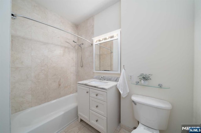 full bathroom featuring tile patterned floors, vanity, toilet, and tiled shower / bath combo