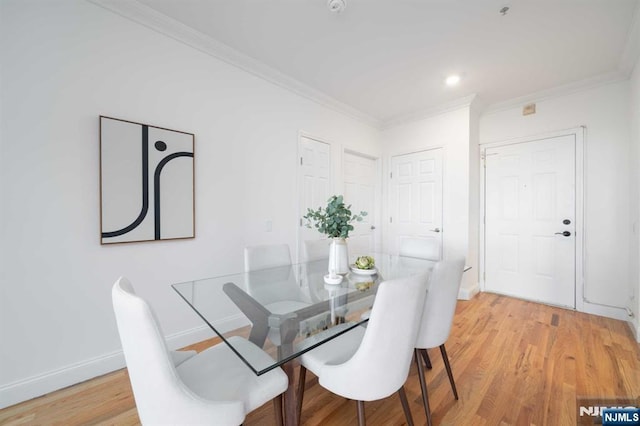 dining area with crown molding and hardwood / wood-style flooring