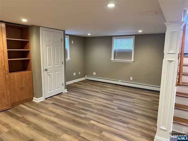 basement with baseboard heating and light hardwood / wood-style floors