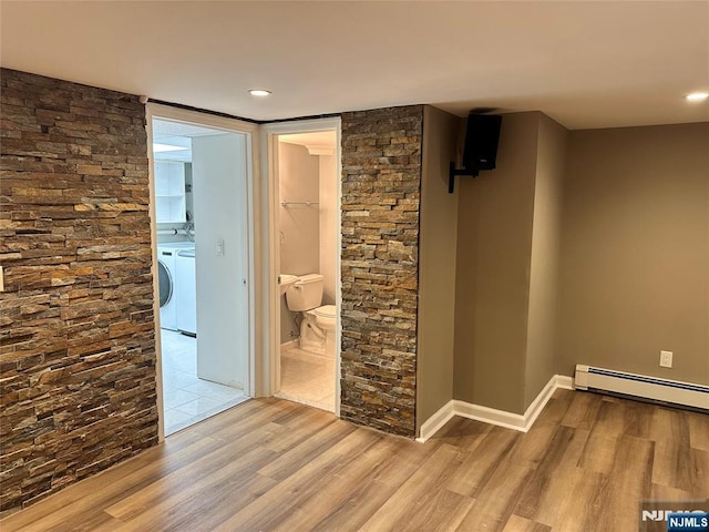 hallway with baseboard heating, washer / clothes dryer, and light hardwood / wood-style floors