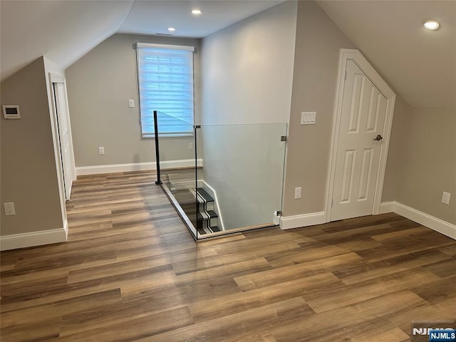 additional living space with wood-type flooring and lofted ceiling