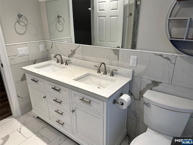 bathroom featuring vanity, tile walls, and toilet