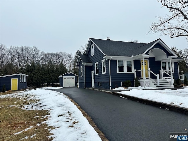 view of front of home with a storage shed and a garage