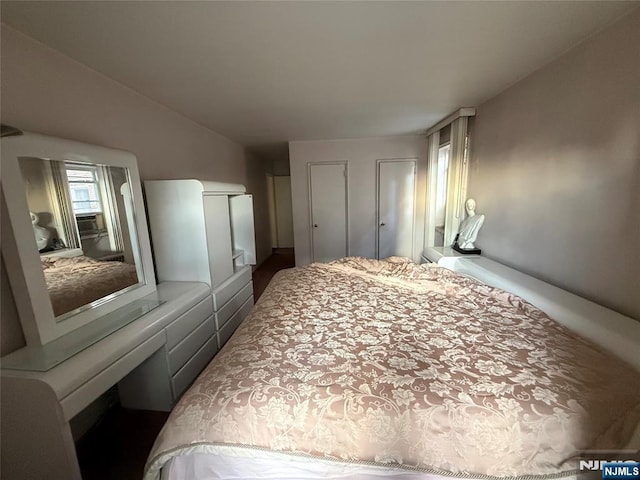 bedroom with vaulted ceiling and multiple closets