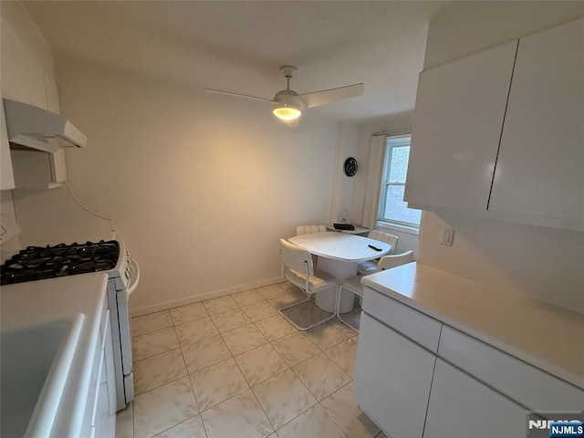 kitchen with sink, white range with gas stovetop, white cabinetry, ventilation hood, and ceiling fan