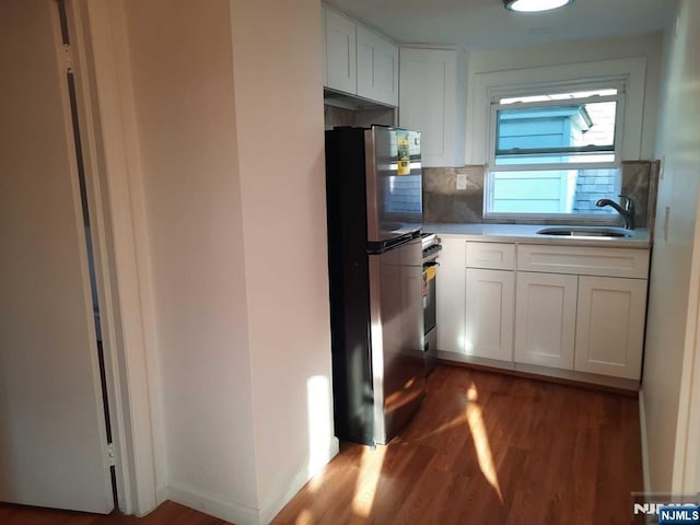 kitchen featuring stainless steel refrigerator, tasteful backsplash, sink, white cabinets, and dark wood-type flooring