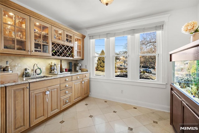 bar with plenty of natural light, baseboards, decorative backsplash, and a sink